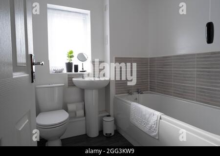 Ein graues Thema Budget Badezimmer Verjüngungskur mit weißen Sanitärkleidung. Stockfoto