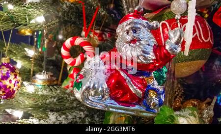 Retro-Weihnachtsmann auf Schlitten winkende Ornament auf altmodischen Weihnachtsbaum Nahaufnahme Stockfoto