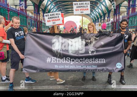 London, Großbritannien. August 2021. Aktivisten von PETA und anderen Gruppen veranstalten einen friedlichen Tierrechtsprotest auf dem Londoner Smithfield Market, in dem sie ein Ende des Speziesismus und die Förderung des Veganismus fordern. Die Demonstranten halten Banner mit den Aufschriften „End Speciesism“ und „We are All Animals“ unter dem legendären Bogendach des Marktes. Hunderte von Tierschützern, organisiert von der Gruppe Animal Rebellion, marschieren durch London, um ein Ende der Ausbeutung von Tieren zu fordern. Penelope Barritt/Alamy Live News Stockfoto