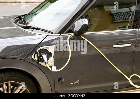 London, England - August 2021: Nahaufnahme eines Elektroautos, das an eine Ladestation angeschlossen ist Stockfoto