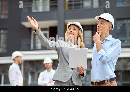 Inspektor und ein Ingenieur in Harthüten, der in die Ferne starrt Stockfoto