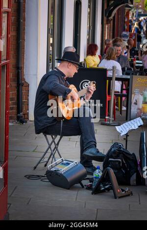 Straßenmusiker spielt Gitarre im Zentrum von Stratford-upon-Avon. Stockfoto