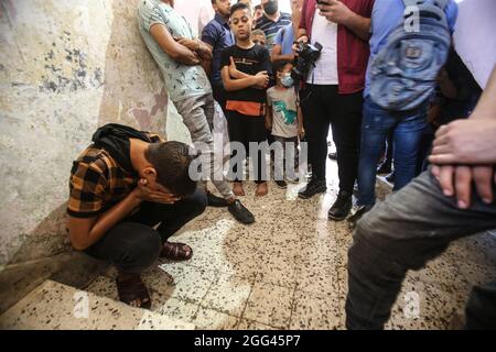 Gaza, Palästina. August 2021. Ein Verwandter eines palästinensischen Teenagers, Omar Abu Neal, trauert während seiner Beerdigung.ein palästinensischer Teenager wurde am 21. August während der von den palästinensischen Fraktionen in der Nähe der Grenze zwischen Israel und dem Gazastreifen organisierten Demonstration gegen den gazastreifen sige und der Verzögerung des Wiederaufbaus im Gazastreifen verletzt Nach Angaben der Hamas-Führer im Gazastreifen wurden rund 40 Menschen verletzt. Ein israelischer Polizeibeamter wurde ebenfalls angeschossen und befand sich in einem kritischen Zustand. Kredit: SOPA Images Limited/Alamy Live Nachrichten Stockfoto
