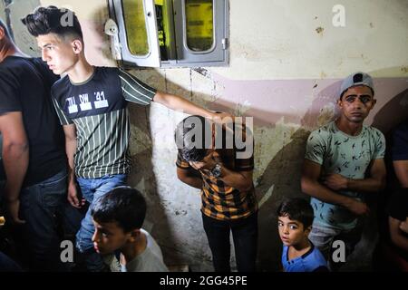 Gaza, Palästina. August 2021. Ein Verwandter eines palästinensischen Teenagers, Omar Abu Neal, trauert während seiner Beerdigung.ein palästinensischer Teenager wurde am 21. August während der von den palästinensischen Fraktionen in der Nähe der Grenze zwischen Israel und dem Gazastreifen organisierten Demonstration gegen den gazastreifen sige und der Verzögerung des Wiederaufbaus im Gazastreifen verletzt Nach Angaben der Hamas-Führer im Gazastreifen wurden rund 40 Menschen verletzt. Ein israelischer Polizeibeamter wurde ebenfalls angeschossen und befand sich in einem kritischen Zustand. Kredit: SOPA Images Limited/Alamy Live Nachrichten Stockfoto