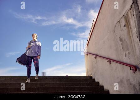 Aktivität Mädchen Läufer hält Sporttasche, Training im Stadion Stockfoto