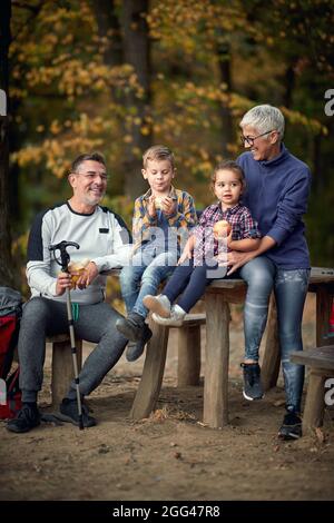 Großmutter, Großvater und Enkel bei einem Snack im Wald an einem schönen Herbsttag Stockfoto