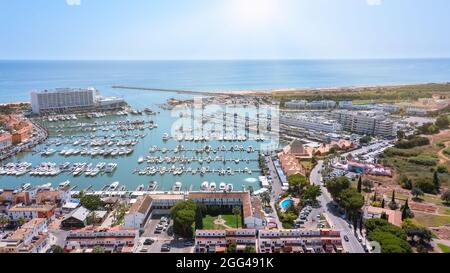 Ein Blick vom Himmel auf die portugiesische Touristenstadt Vilamoura, mit Yachten und Segelbooten, die im Hafen auf dem Dock festgemacht sind. Stockfoto