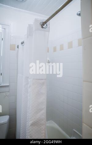 Weiße Dusche im Badezimmer mit Vintage-Fliesen in der alten Hütte Stockfoto