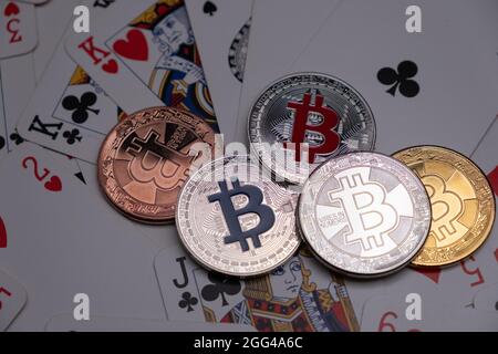 Bitcoins auf Spielkarten Hintergrund. Kryptowährungskonzept, Bitcoin BTC und Game Cards. Kryptowährung liegt in der Nahaufnahme von Spielkarten. Stockfoto
