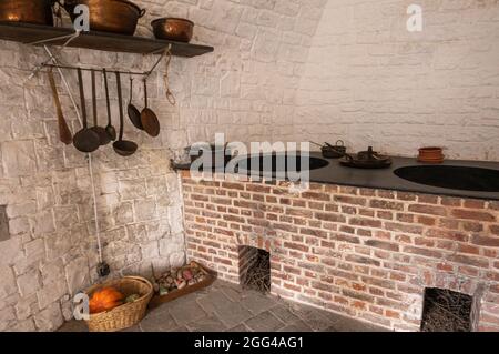 Dinant, Wallonien, Belgien - 8. August 2021: Festung Zitadelle. Teil des Küchenbereichs mit Doppelkamin und Geschirr. Stockfoto