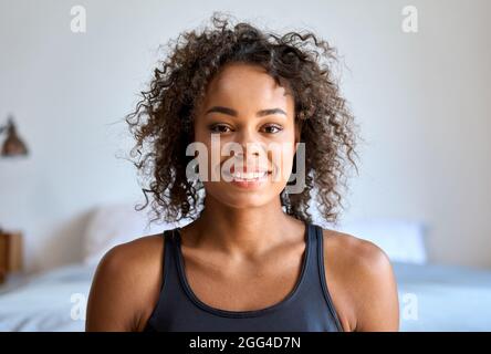 Headshot-Porträt einer jungen Frau mit gemischtem Rennen, die in Innenräumen die Kamera anschaut. Stockfoto