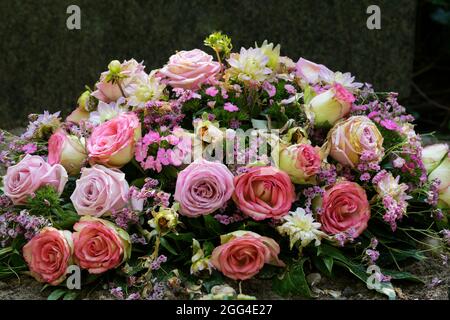 Bunte Pastellblumen auf einem Grab nach einer Beerdigung Stockfoto