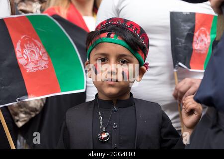 London, Großbritannien. August 2021. Ein afghanisches Kind mit den Farben der afghanischen Flagge, während der Demonstration in Westminster.die Afghanen versammelten sich in London, organisiert von der Watan, um Terrorakte der Taliban in Afghanistan zu verurteilen. Die Watan als Organisation, die das Bewusstsein für die aktuelle humanitäre Krise in Afghanistan schärft und versucht, ausländische Kräfte zu vereinen, um den Frieden im Land wiederherzustellen. Sie fordern, dass Stellvertreterkriege jetzt in Afghanistan gestoppt werden. Kredit: SOPA Images Limited/Alamy Live Nachrichten Stockfoto