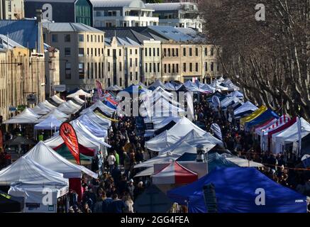 Geschäftigen Wintermorgen auf dem Salamanca Market in Hobart mit Ständen für Kunst und Kunsthandwerk, Speisen und Produkte und einer großen Menschenmenge von Einkäufern Stockfoto