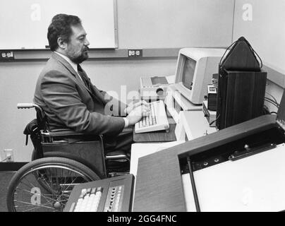 Austin Texas USA, um 1990: Der legal blinde IBM-Computerprogrammierer im Rollstuhl arbeitet am Computer in seinem Büro. ©Bob Daemmrich Stockfoto