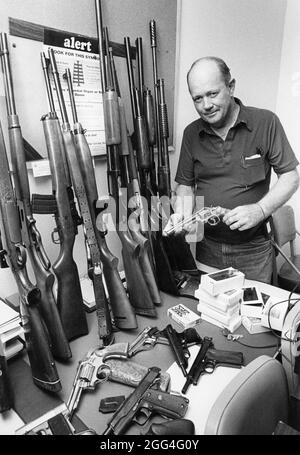 Austin Texas USA, um 1985: Polizeidetektiv von Austin mit gestohlenen Waffen, die bei einer Razzia auf dem Haus eines Drogenhändlers gefunden wurden. ©Bob Daemmrich Stockfoto