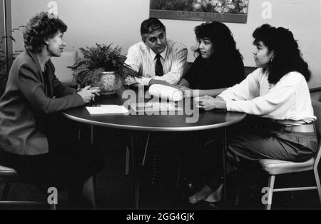 Austin Texas USA, um 1988: Die hispanische Mutter und ihr Vater kommen zu ihrer Tochter im Büro ihres High School Counselors, um Familienfragen zu besprechen. ©Bob Stockfoto