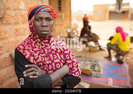 Yaoumou Arama (50) floh vor Gewalt und Unsicherheit im Nordosten von Burkina Faso und lebt heute als Binnenvertriebene in der westlichen Stadt Nouna. Yaoumou ist die alleinige Ernährerin ihrer siebenköpfigen Familie und bringt ein karges Leben ein, indem sie kocht und Snacks und Mahlzeiten an die Nachbarn verkauft. Ihr älterer Mann ist kränkeln und arbeitsunfähig. Ihre Jugendlichen und erwachsenen Kinder können keine Arbeit finden. Die Familie lebt auf einem kleinen, gemieteten Grundstück, wo man nirgendwo landwirtschaftlicher machen kann, und kämpft mit Hunger und genug Geld, um Lebensmittel zu kaufen. „Ich genieße das Leben hier nicht“, sagt sie. „Es gibt keinen Arbeitsplatz. Wenn ich hier auf der Farm wäre Stockfoto