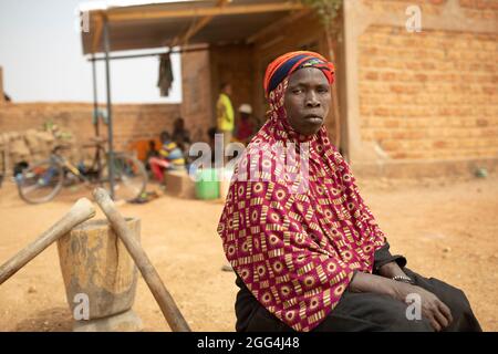 Yaoumou Arama (50) floh vor Gewalt und Unsicherheit im Nordosten von Burkina Faso und lebt heute als Binnenvertriebene in der westlichen Stadt Nouna. Yaoumou ist die alleinige Ernährerin ihrer siebenköpfigen Familie und bringt ein karges Leben ein, indem sie kocht und Snacks und Mahlzeiten an die Nachbarn verkauft. Ihr älterer Mann ist kränkeln und arbeitsunfähig. Ihre Jugendlichen und erwachsenen Kinder können keine Arbeit finden. Die Familie lebt auf einem kleinen, gemieteten Grundstück, wo man nirgendwo landwirtschaftlicher machen kann, und kämpft mit Hunger und genug Geld, um Lebensmittel zu kaufen. „Ich genieße das Leben hier nicht“, sagt sie. „Es gibt keinen Arbeitsplatz. Wenn ich hier auf der Farm wäre Stockfoto