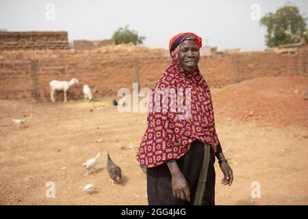 Yaoumou Arama (50) floh vor Gewalt und Unsicherheit im Nordosten von Burkina Faso und lebt heute als Binnenvertriebene in der westlichen Stadt Nouna. Yaoumou ist die alleinige Ernährerin ihrer siebenköpfigen Familie und bringt ein karges Leben ein, indem sie kocht und Snacks und Mahlzeiten an die Nachbarn verkauft. Ihr älterer Mann ist kränkeln und arbeitsunfähig. Ihre Jugendlichen und erwachsenen Kinder können keine Arbeit finden. Die Familie lebt auf einem kleinen, gemieteten Grundstück, wo man nirgendwo landwirtschaftlicher machen kann, und kämpft mit Hunger und genug Geld, um Lebensmittel zu kaufen. „Ich genieße das Leben hier nicht“, sagt sie. „Es gibt keinen Arbeitsplatz. Wenn ich hier auf der Farm wäre Stockfoto