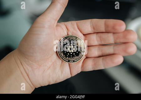 Kryptowährung-Münze von Cardano Ada aus der Nähe in der Hand gehalten Stockfoto