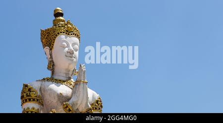 Nahaufnahme der alten Engelskulptur in Gebetsgesten mit blauem Himmel Hintergrund. Stockfoto