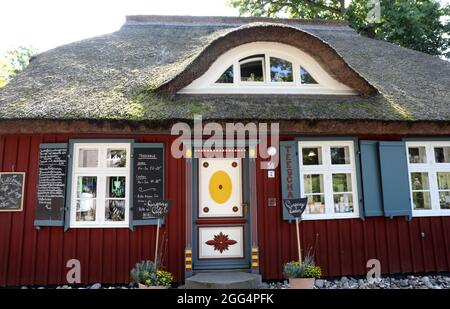 Prerow, Deutschland. August 2021. Eine alte Darsstür an der 'Teeschale'. Die ursprünglichen Darss-Türen wurden zwischen 1790 und 1850 geschaffen, typischerweise geschnitzte Ornamente mit Bezug auf die Seefahrt oder die Natur. Die Türen gehörten zu den repräsentativen Häusern der damaligen Seeleute, die es zu einem gewissen Wohlstand gebracht hatten. Quelle: Bernd Wüstneck/dpa-Zentralbild/ZB/dpa/Alamy Live News Stockfoto