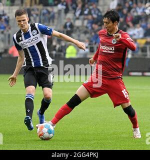 Bielefeld, Deutschland. August 2021. Fabian Kunze (L) aus Bielefeld steht mit dem Frankfurter Kamada Daichi während des Bundesligaspiels der DSC Arminia Bielefeld und der Eintracht Frankfurt am 28. August 2021 in Bielefeld auf dem Spiel. Quelle: Ulrich Hufnagel/Xinhua/Alamy Live News Stockfoto