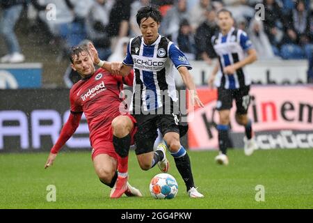 Bielefeld, Deutschland. August 2021. Okugawa Masaya (R) aus Bielefeld steht mit Christopher Lenz aus Frankfurt am 28. August 2021 während des Bundesliga-Fußballspiels der DSC Arminia Bielefeld und Eintracht Frankfurt in Bielefeld vor. Quelle: Ulrich Hufnagel/Xinhua/Alamy Live News Stockfoto