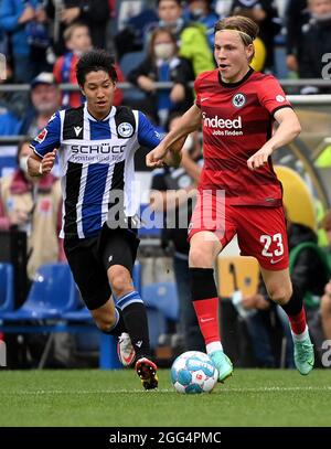 Bielefeld, Deutschland. August 2021. Okugawa Masaya (L) aus Bielefeld steht mit Jens Petter Hauge aus Frankfurt am 28. August 2021 während des Bundesliga-Fußballspiels der DSC Arminia Bielefeld und der Eintracht Frankfurt in Bielefeld vor. Quelle: Ulrich Hufnagel/Xinhua/Alamy Live News Stockfoto