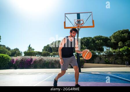 Basketballspieler läuft beim Training über das Basketballfeld. Sommer Stockfoto