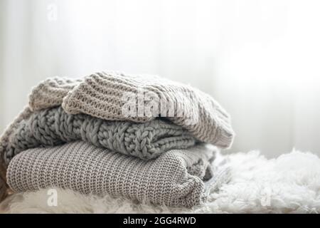 Nahaufnahme eines Stapels gestrickter Pullover auf unscharfem Hintergrund. Stockfoto