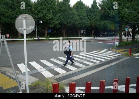 Tokio, Japan. August 2021. Paralympics: Ein Polizeibeamter geht über einen Fußgängerüberweg im Olympiastadion in Tokio. Kredit: Marcus Brandt/dpa/Alamy Live Nachrichten Stockfoto