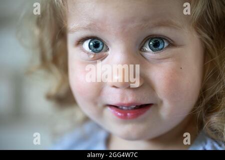 Porträt eines kleinen Mädchens mit großen blauen Augen, mit Tränen befleckten Augen eines Kindes. Stockfoto