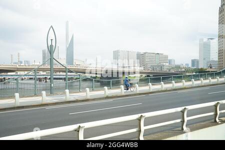 Tokio, Japan. August 2021. Paralympics: Ein Mann in Uniform fährt mit dem Fahrrad über eine Brücke. Kredit: Marcus Brandt/dpa/Alamy Live Nachrichten Stockfoto