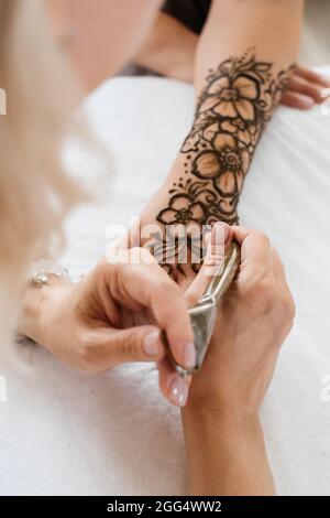 Draufsicht Kunst Henna Tattoo auf Frauen Hände. Master Künstler Zeichnung Arabisch Mehndi für Braut vor der Hochzeit. Nahaufnahme, Ansicht von oben. Florales Dessin. Kegel Stockfoto