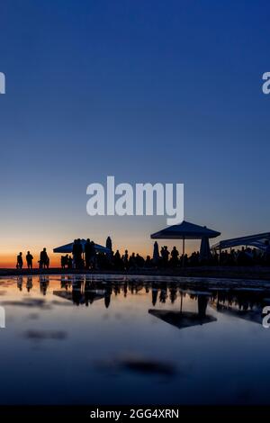 Silhouetten der Menge an der Strandbar während des Sonnenuntergangs Stockfoto