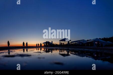 Silhouetten der Menge an der Strandbar während des Sonnenuntergangs Stockfoto