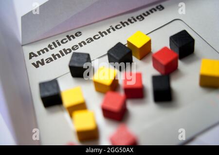 Schwarze Briefe auf weißem Umschlag mit der Aussage: Offizielle Wahlbenachrichtigung. Holzwürfel in schwarz-rotem Gold. 2021 f Stockfoto