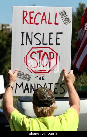 Olympia, Usa. August 2021. Ein Protestler hält ein Plakat, auf dem der Gouverneur von Washington, Jay Inslee, während der Demonstration gegen ein kürzlich erzwungene COVID-19-Impfmandat für einige öffentliche Angestellte im Bundesstaat Washington zum Rückruf aufgerufen wird. Kredit: SOPA Images Limited/Alamy Live Nachrichten Stockfoto