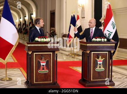 Bagdad, Irak. August 2021. Der irakische Präsident Barham Salih (R) und der französische Präsident Emmanuel Macron nehmen am 28. August 2021 an einer Pressekonferenz in Bagdad, Irak, Teil. Der Irak hat am Samstag die Konferenz für Zusammenarbeit und Partnerschaft in Bagdad abgehalten, an der neun Länder und mehrere regionale und internationale Organisationen teilnahmen, um die Sicherheit und wirtschaftliche Zusammenarbeit im Nahen Osten zu fördern. Quelle: Khalil Dawood/Xinhua/Alamy Live News Stockfoto