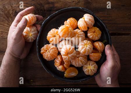 Präsentation von geschälten Mandarinen auf alten Holztisch Stockfoto