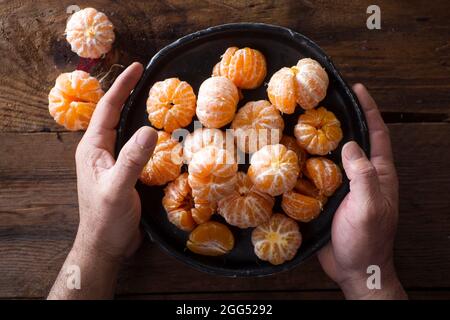 Präsentation von geschälten Mandarinen auf alten Holztisch Stockfoto