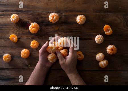 Präsentation von geschälten Mandarinen auf alten Holztisch Stockfoto