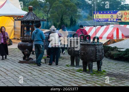 Verehrer brennende Räucherstäbchen am buddhistischen Tempel Guan Dao Guan Ying Stockfoto