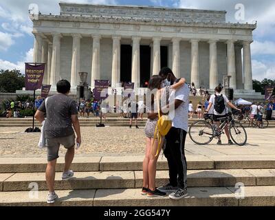 28. August 2021, Washington, District of Columbia, USA: Am 58. Jahrestag des Marsches auf Washington versammelten sich Menschen bei der Make Good Trouble Rallye am Lincoln Memorial. Im Jahr 1963, als der erste märz stattfand, wäre eine Versammlung, bei der ein multirassisches Paar frei umarmt oder verheiratet werden konnte, in DC legal gewesen, aber nicht in 16 Staaten. Im Jahr 1967 schlug der Oberste Gerichtshof in Loving v. Virginia solche Gesetze nieder, die als Meilenstein für die Bürgerrechte galten. (Bild: © Sue Dorfman/ZUMA Press Wire) Stockfoto