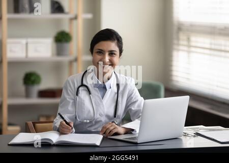 Porträt einer jungen lächelnden, selbstbewussten indischen Ärztin. Stockfoto