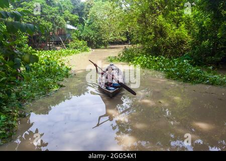 Munshiganj, Bangladesch. August 2021. Ein Mann rudert sein kleines Boot, während die Erosion des Flusses Padma weiterhin Betonstrukturen in Tongibari, Munshiganj Bezirk, am Stadtrand von Dhaka, wegspült.nach dem Monsun haben sich heftige Erosionen in die Ufer des Padma-Flusses gefressen, was große Teile in Munshiganj, Tongibari Upazila, Bangladesch, bedrohte. (Foto von Nayan Kar/SOPA Images/Sipa USA) Quelle: SIPA USA/Alamy Live News Stockfoto