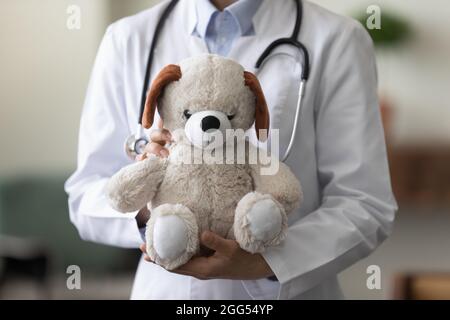 Nahaufnahme Fokus auf Teddybär in weiblichen Ärztehinden. Stockfoto