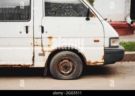 Weiß rostig aufgegeben kompakten Van. Unnötige Fehlfunktionen Auto Trödelwagen auf der Seite der Straße aufgegeben Stockfoto